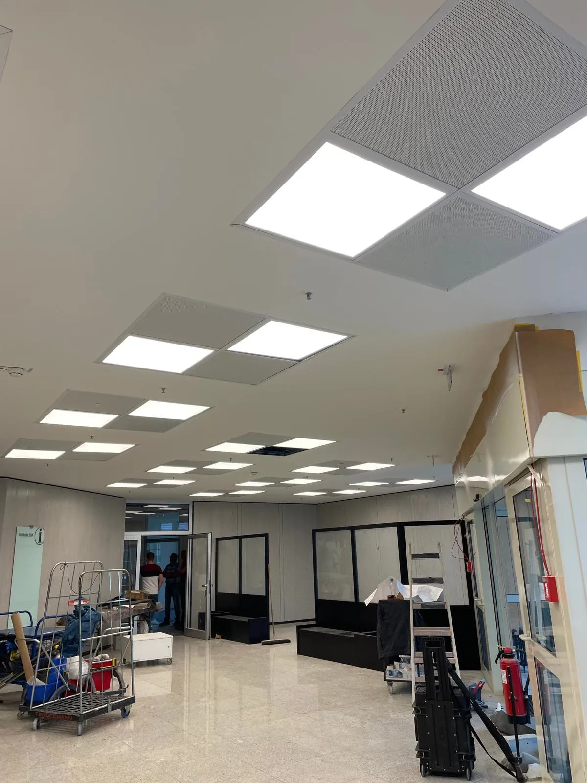 Bürodecke mit eingelassenen LED-Panelen und Akustikeinlagen