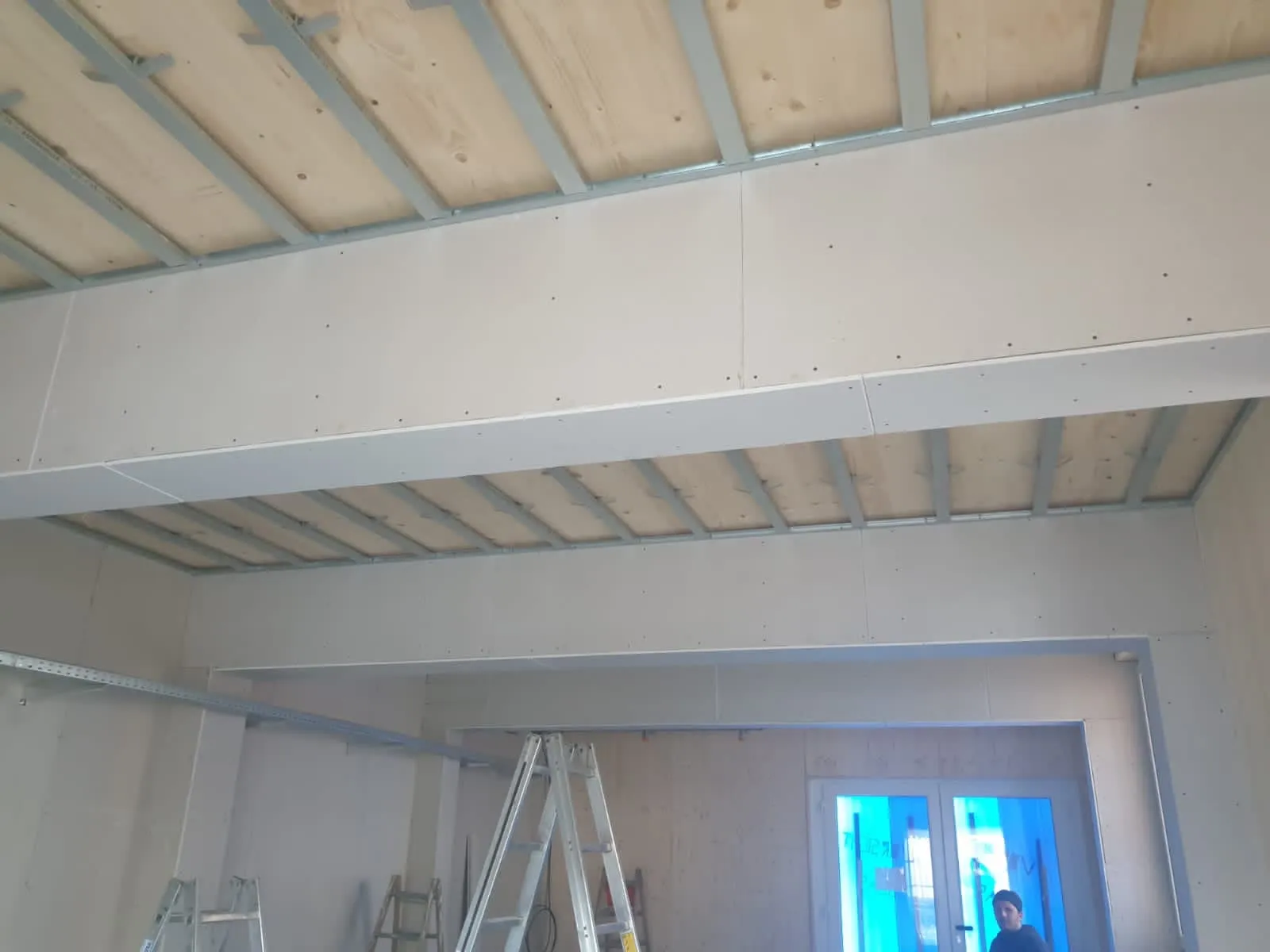 Abgehängte Decke unter Holzbalkenlage mit Metallprofilen