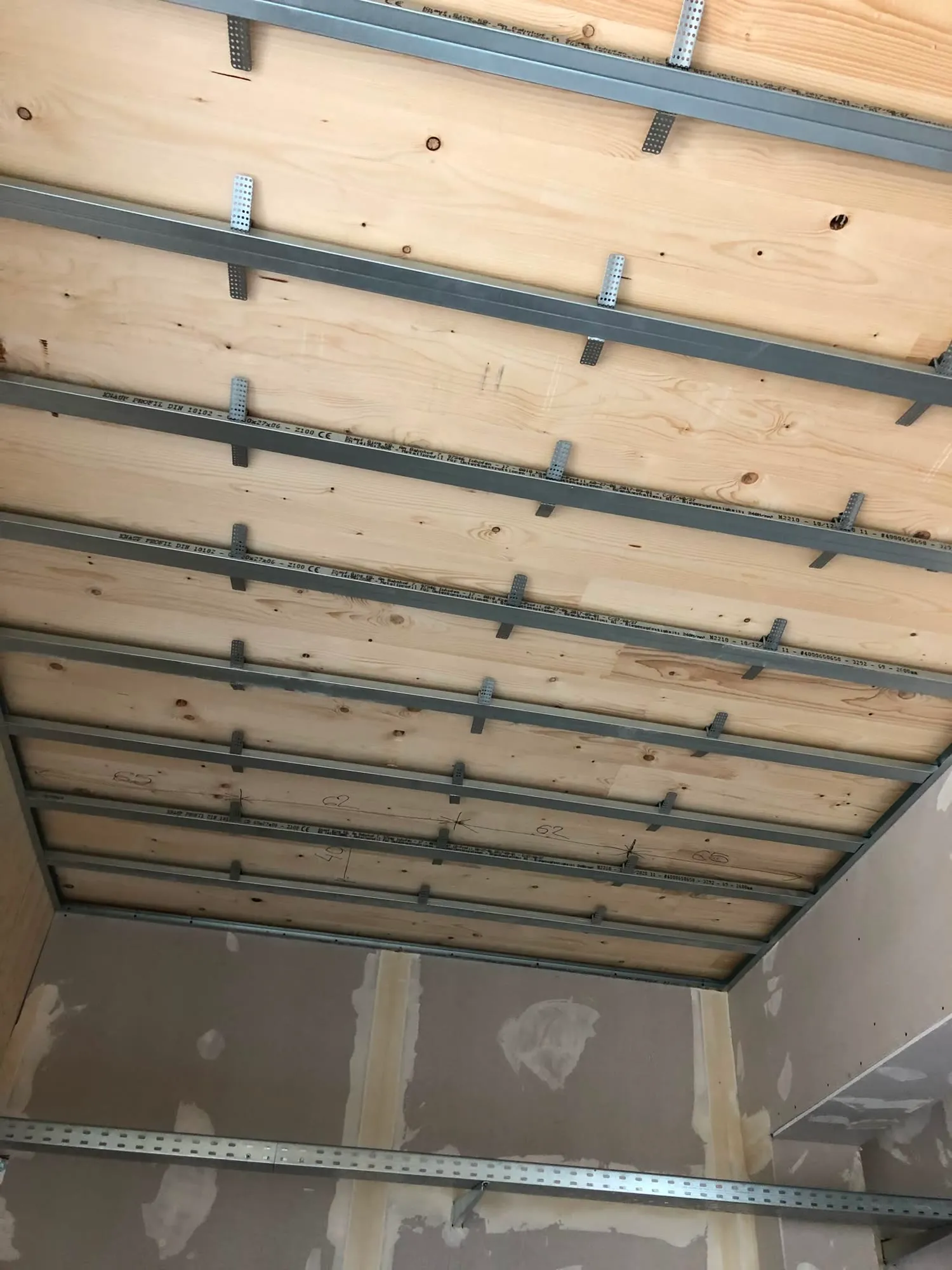 Metallunterkonstruktion an einer Holzdecke vor der Beplankung