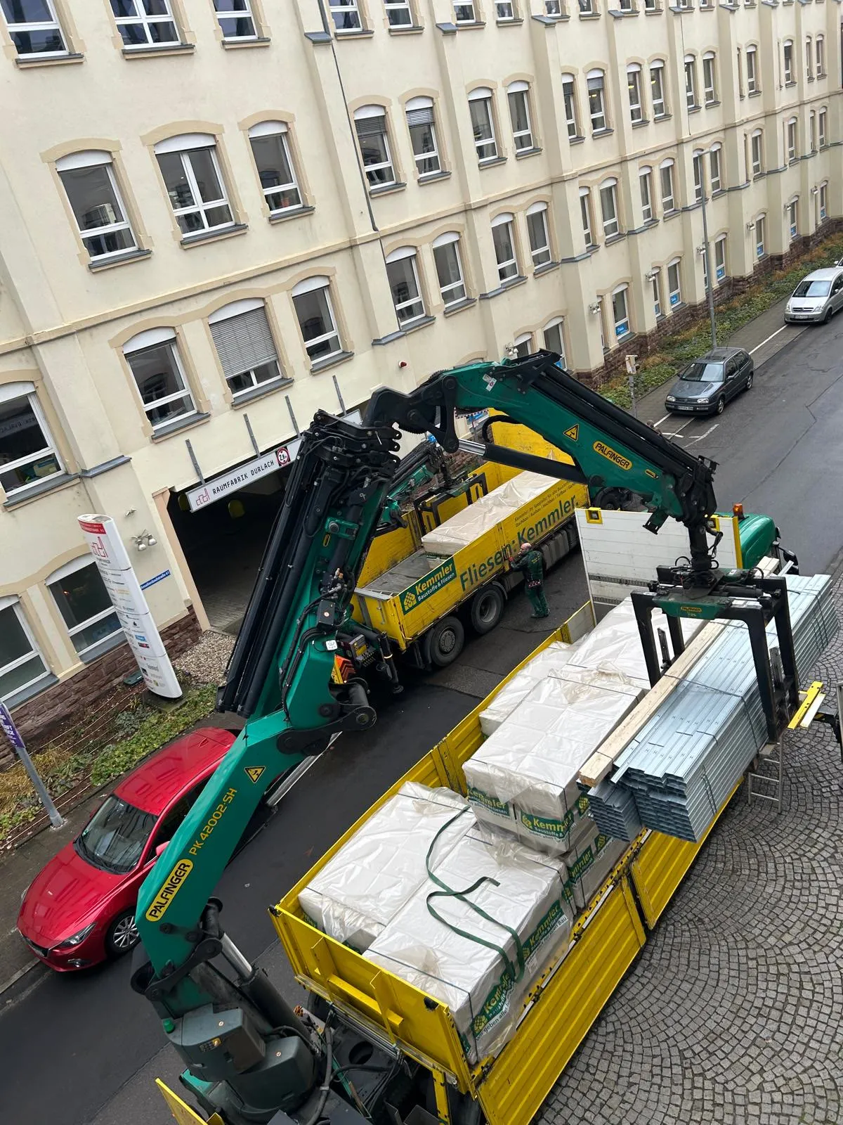 Materialanlieferung per Kranfahrzeug an der Baustelle