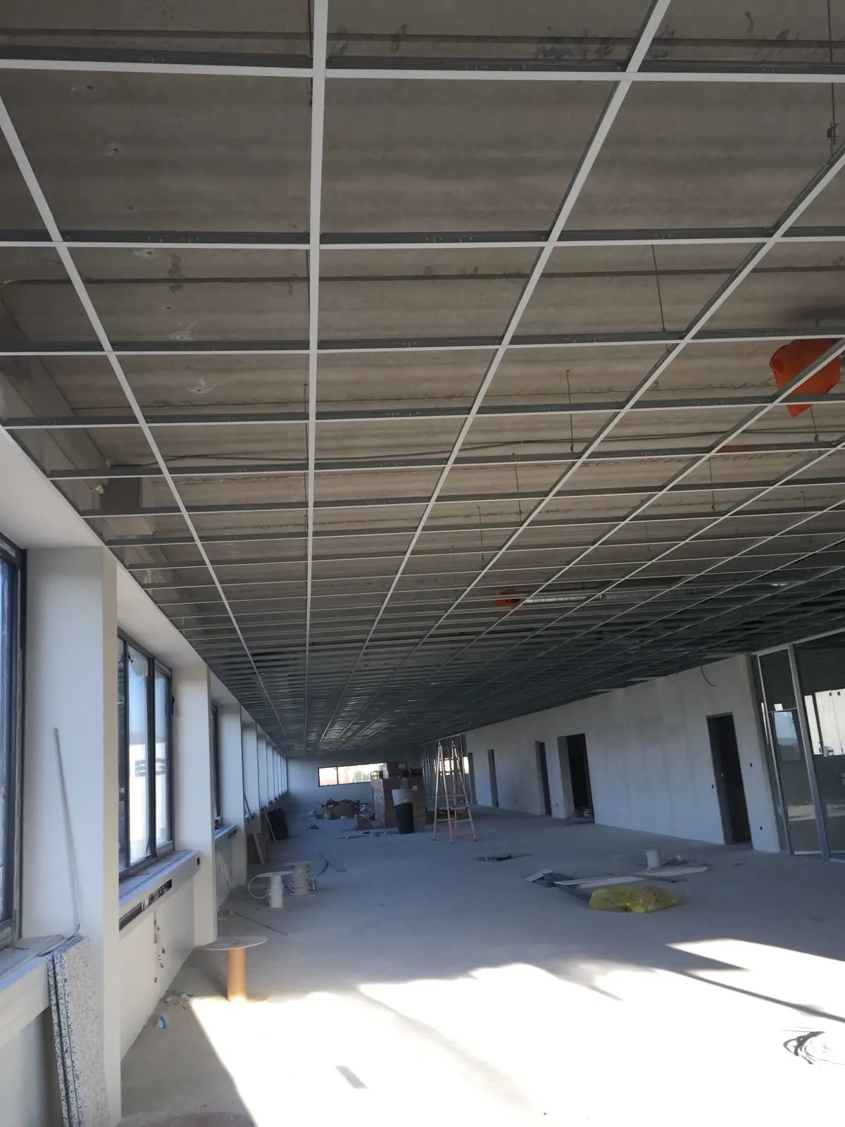 Rasterdecke im Aufbau mit Tageslicht aus der Fensterfront